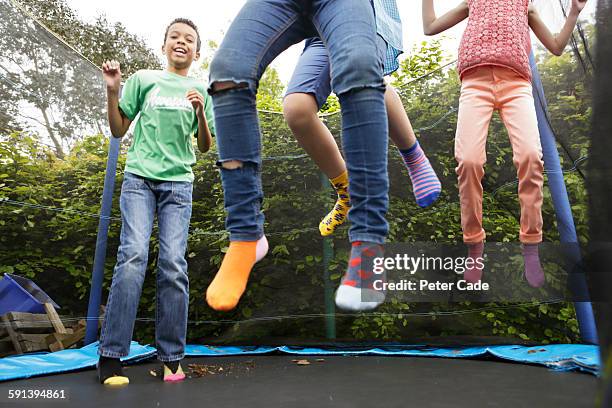 children jumping on trampoline - trampoline photos et images de collection