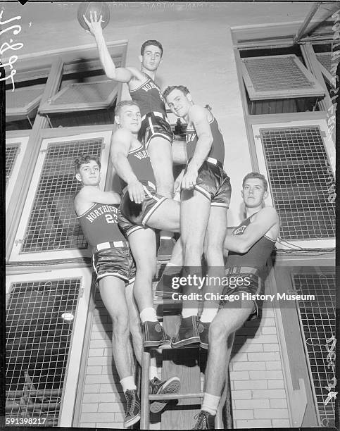 Northwestern University basketball team members standing on ladder, Chicago, Illinois, December 1934