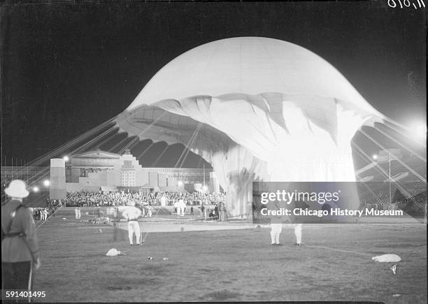 Crowds watch Auguste Piccard inflating the Stratosphere Balloon for flight in Soldier Field at the 1933 Chicago World's Fair, A Century of Progress...