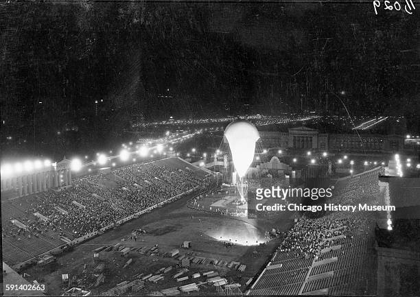 Crowds watch Auguste Piccard inflating the Stratosphere Balloon for flight in Soldier Field at the 1933 Chicago World's Fair, A Century of Progress...