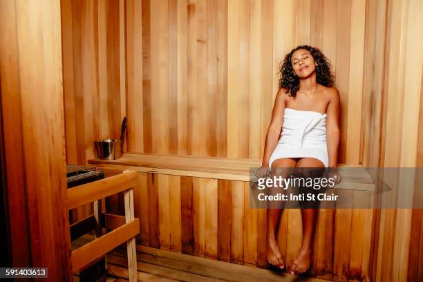 smiling woman relaxing in sauna - woman with towel spa stock pictures, royalty-free photos & images