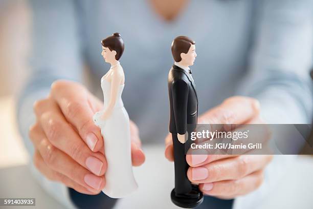 hands holding bride and groom cake toppers - wedding planning foto e immagini stock