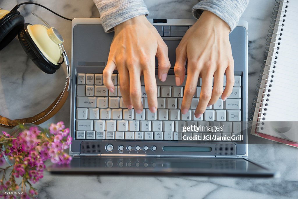 Mixed race woman using laptop at table