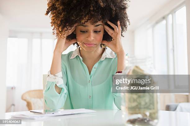 stressed mixed race woman paying bills - woman money stock pictures, royalty-free photos & images