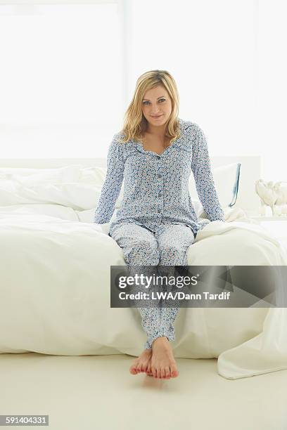 caucasian woman sitting on bed - lwa dann tardif bed stock pictures, royalty-free photos & images