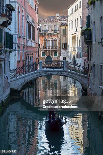 gondolier sailing on venice canal, veneto, italy - gondola traditional boat stockfoto's en -beelden