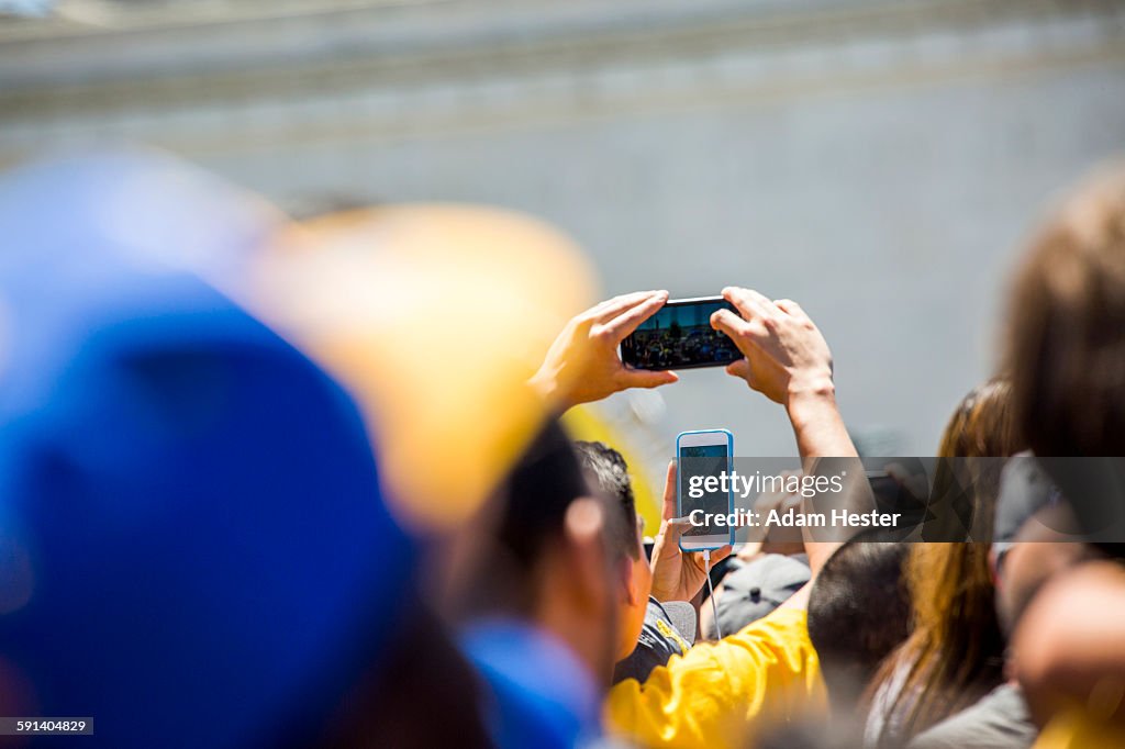 Crowd of fans photographing sporting event