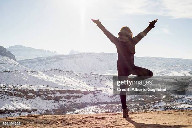 caucasian woman practicing yoga on remote hilltop - endast en medelålders kvinna bildbanksfoton och bilder