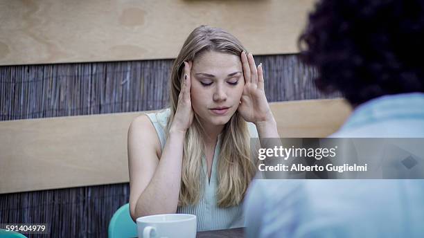 stressed caucasian woman sitting at table - alberto stock-fotos und bilder