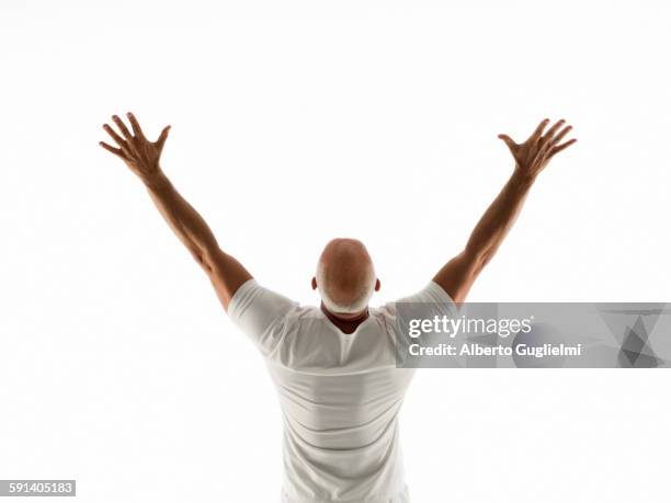 rear view of older man cheering with arms raised - man outstretched arms ストックフォトと画像