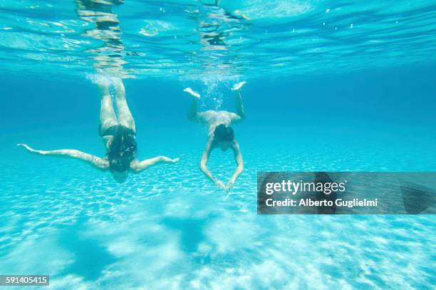 underwater view of women swimming in ocean - stintino stock pictures, royalty-free photos & images