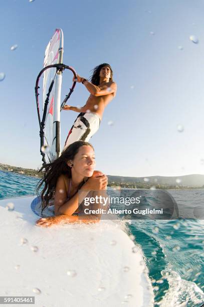 low angle view of couple windsurfing on ocean - windsurfing fotografías e imágenes de stock