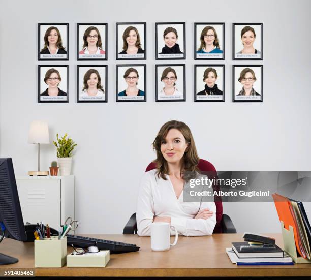 businesswoman smiling under award pictures in office - woman awards 2015 stock-fotos und bilder