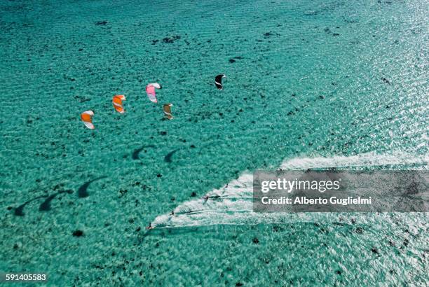 aerial view of people kitesurfing on ocean - kite surfing stock pictures, royalty-free photos & images