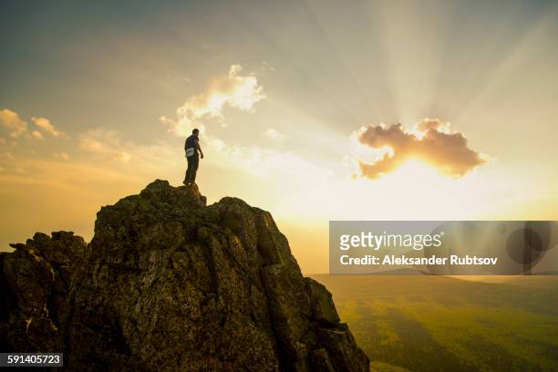 caucasian hiker on rocky hilltop in remote landscape - summits russia 2015 stock pictures, royalty-free photos & images
