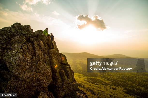 caucasian hikers on rocky hilltop in remote landscape - summits russia 2015 stock pictures, royalty-free photos & images