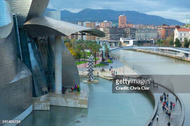 aerial view of tourists on walkway over urban canal, bilbao, biscay, spain - bilbao stock pictures, royalty-free photos & images