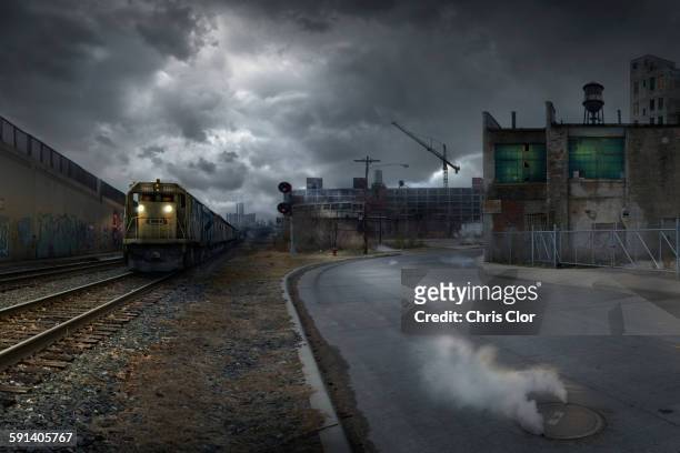 train on train tracks in dilapidated industrial city - spooky train stock pictures, royalty-free photos & images