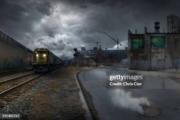 train on train tracks in dilapidated industrial city - fantasy factory stock pictures, royalty-free photos & images