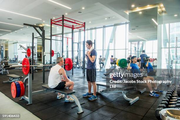 people working out in gymnasium - gym stock-fotos und bilder