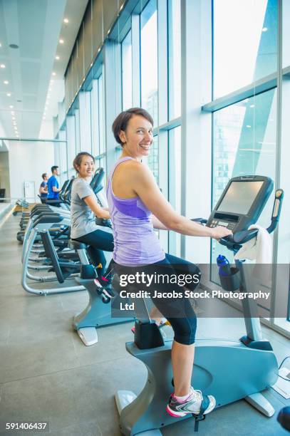 women working out on spin machines in gymnasium - 2015 40 stock pictures, royalty-free photos & images