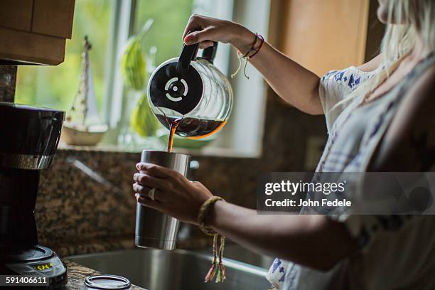 caucasian woman pouring cup of coffee in kitchen - flask stock pictures, royalty-free photos & images