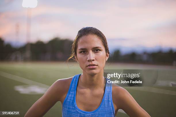 mixed race athlete standing on sports field - athlete stock pictures, royalty-free photos & images