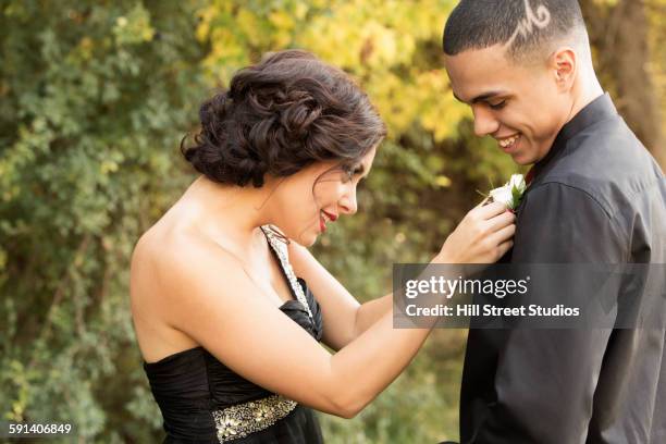 teenage girl attaching corsage to prom date - corsage imagens e fotografias de stock