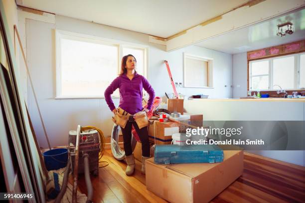 mixed race woman surveying remodeling project - diy kitchen stock pictures, royalty-free photos & images