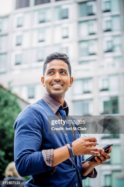 indian businessman using cell phone outdoors - asian businessman happy stock pictures, royalty-free photos & images