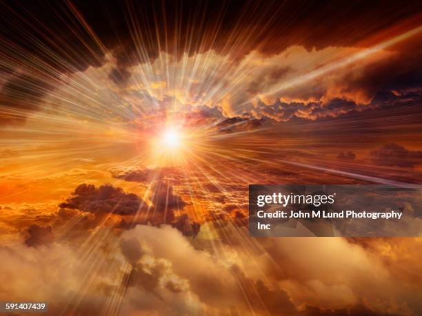 sunbeams shining through clouds in dramatic sky - spirituele verlichting stockfoto's en -beelden