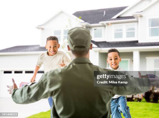 returning soldier greeting children outside house - honors 2015 arrivals stock pictures, royalty-free photos & images