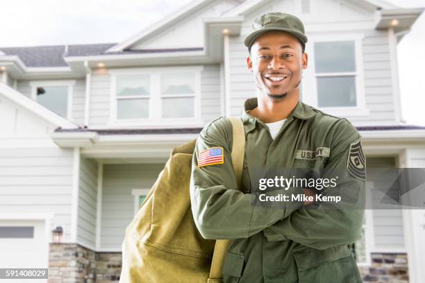 black soldier standing outside house - american soldier stock-fotos und bilder