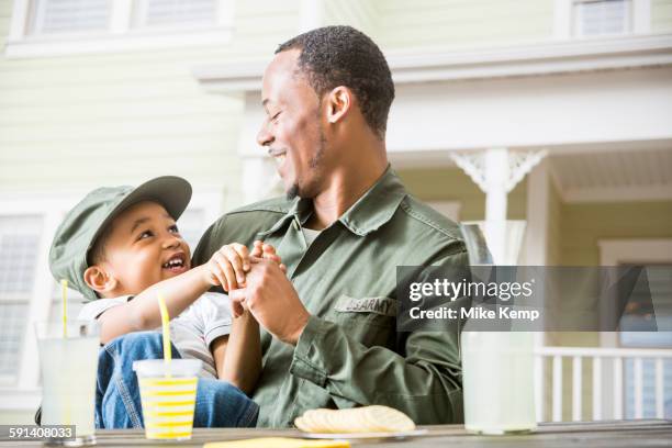 father and son relaxing in backyard - honors 2015 arrivals stock pictures, royalty-free photos & images