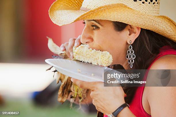 close up of hispanic woman eating corn - corn cob stock pictures, royalty-free photos & images