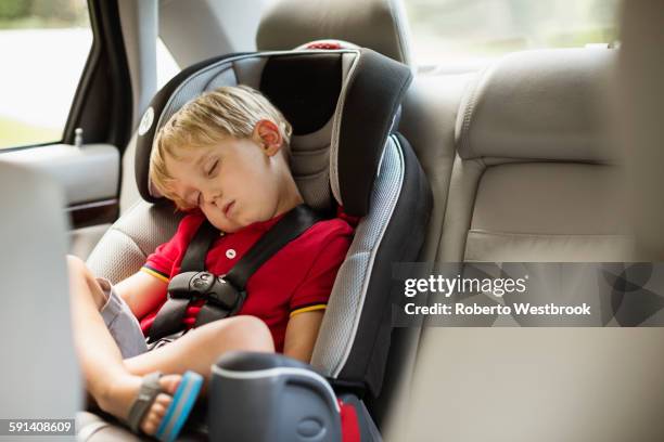 caucasian boy napping in car seat - sleeping in car stockfoto's en -beelden