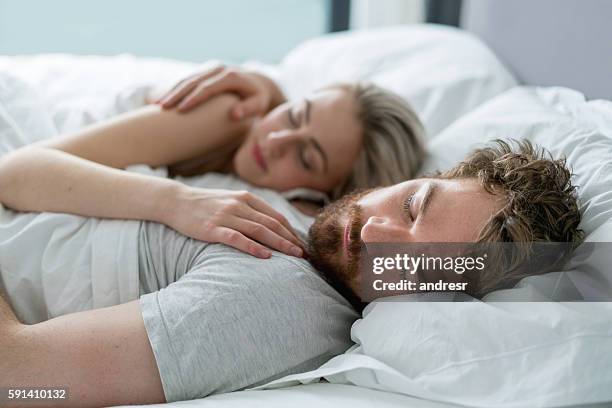 couple sleeping in bed at home - tranquil scene couple stock pictures, royalty-free photos & images
