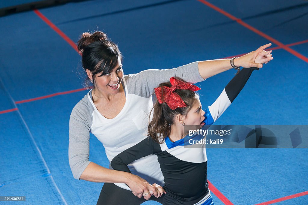Coach helping autistic girl on cheerleading team