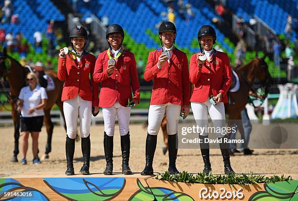 Silver medalists Lucy Davis of United States riding Barron, Kent Farrington of the United States riding Voyeur, McLain Ward of United States riding...