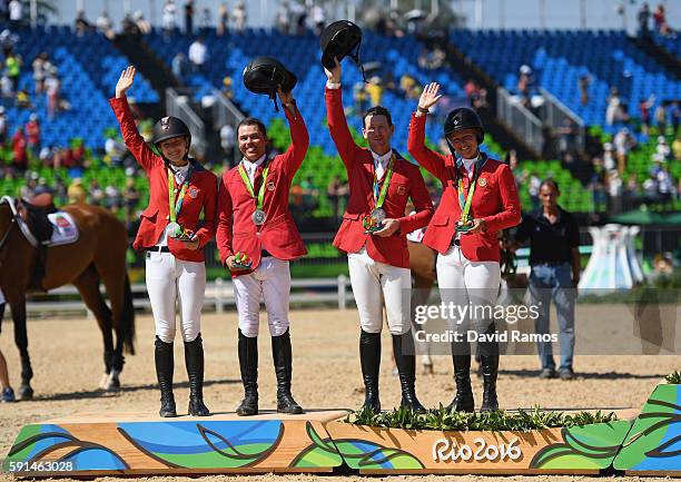 Silver medalists Lucy Davis of United States riding Barron, Kent Farrington of the United States riding Voyeur, McLain Ward of United States riding...