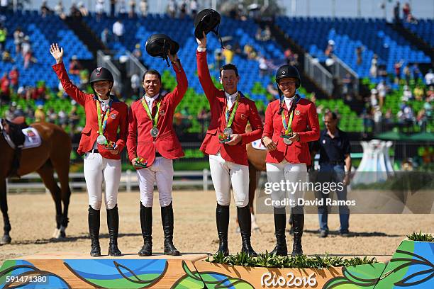 Silver medalists Lucy Davis of United States riding Barron, Kent Farrington of the United States riding Voyeur, McLain Ward of United States riding...