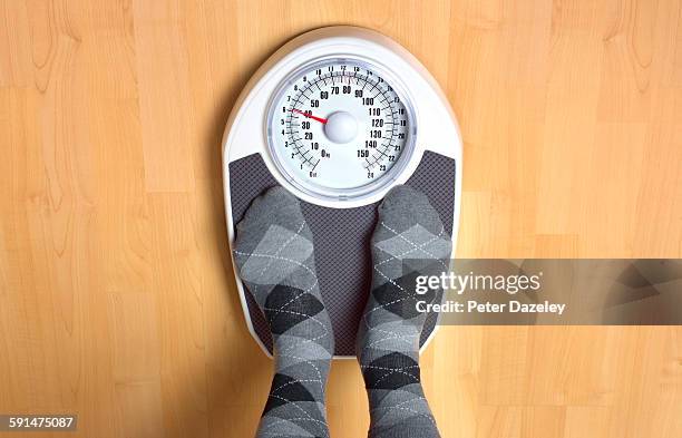 male anorexic weighing himself - anorexia nervosa stock pictures, royalty-free photos & images