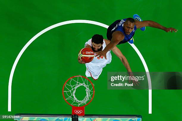 Nikola Mirotic of Spain goes to the basket under pressure against Boris Diaw of France during the Men's Quarterfinal match on Day 12 of the Rio 2016...