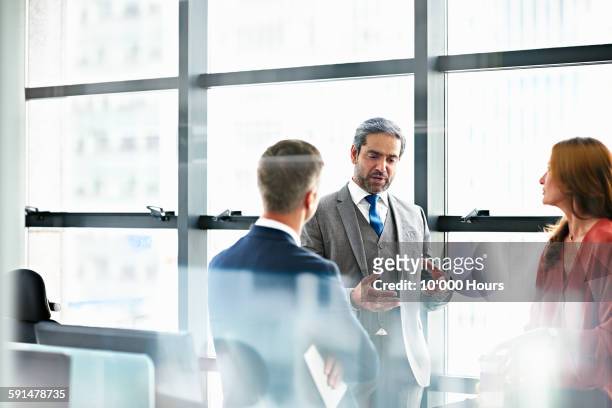 business people discussing plans in modern office - abbigliamento da lavoro formale foto e immagini stock