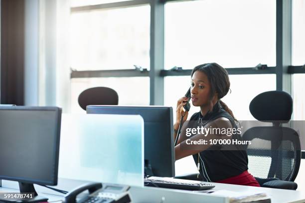 businesswoman talking on the phone in office - festnetztelefon stock-fotos und bilder