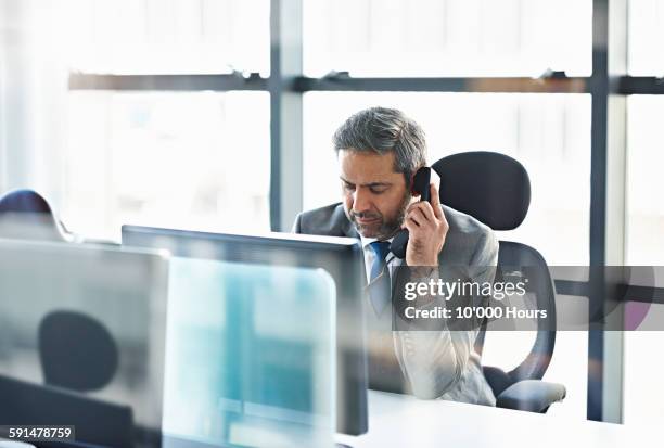 businessman talking on the phone in modern office - landline phone imagens e fotografias de stock