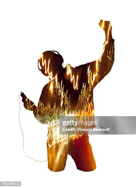 silhouette of a man listenning to headphones music - long exposure dancer stock-fotos und bilder