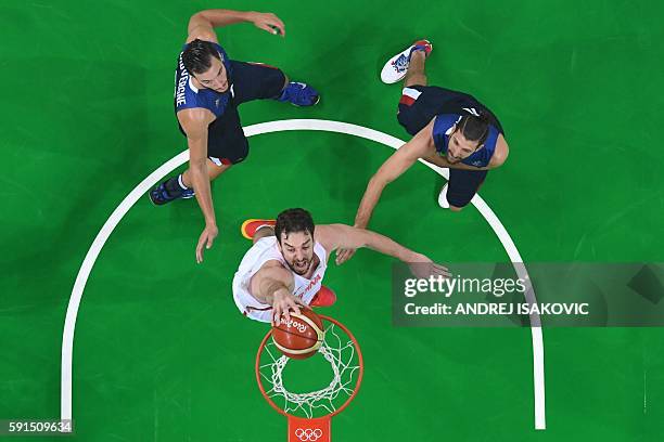 An overview shows Spain's centre Pau Gasol score past France's power forward Joffrey Lauvergne and France's point guard Antoine Diot during a Men's...