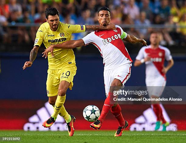 Roberto Soriano of Villarreal competes for the ball with Nabil Dirar of Monaco during the UEFA Champions League play-off first leg match between...