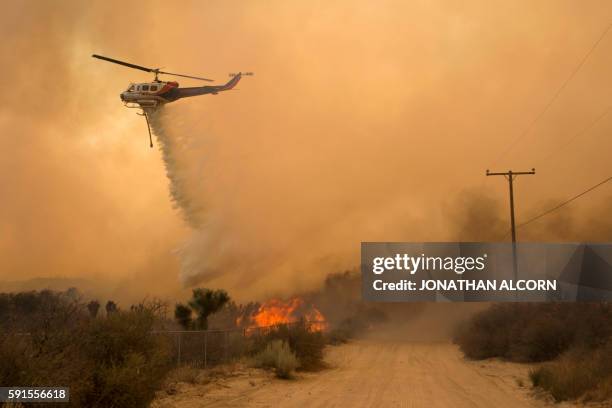Helicopter makes a water drop at the Blue Cut wildfire in Phelan,California on August 17, 2016. A fire raging east of Los Angeles spread rapidly...